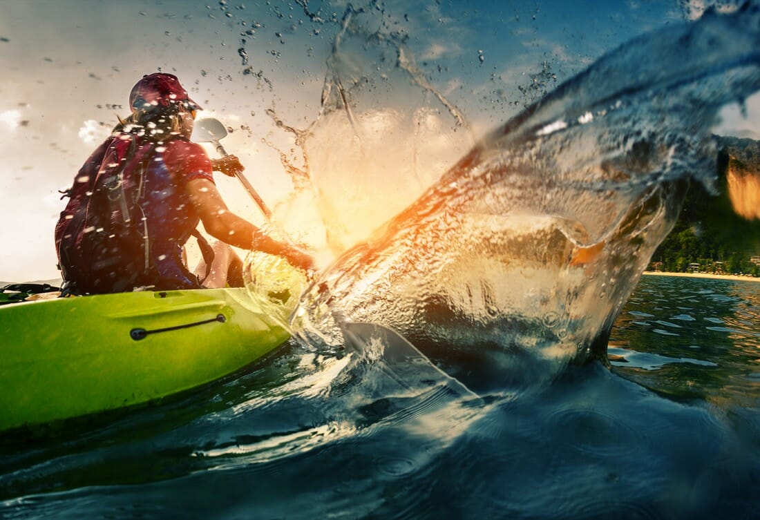 Kayaker in water at sunset