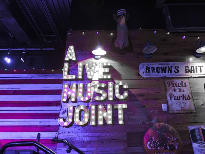 A sign saying - live music joint at a bar on International Drive