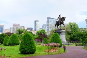 Equestrian statue of George Washington in Boston Common surrounded by plants and flowers.