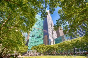 Sunny day in Bryant Park with modern buildings framed by trees