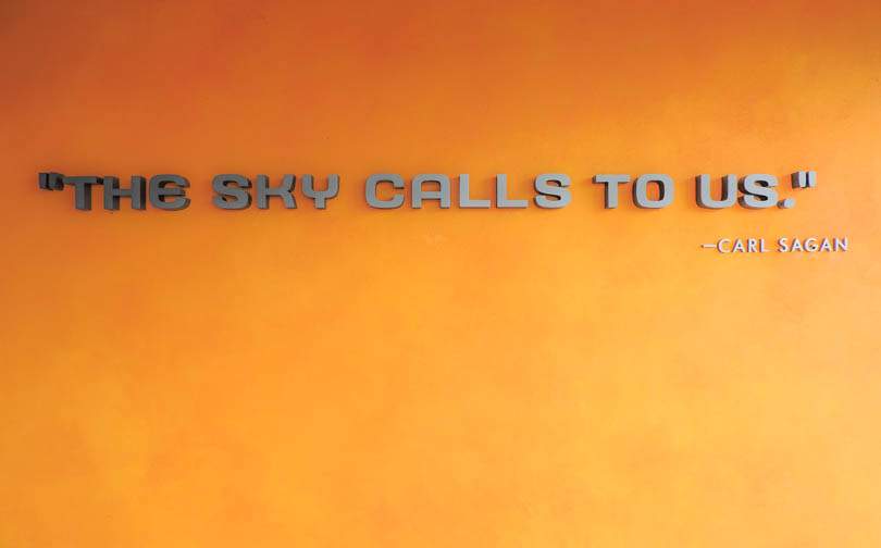 Carl Sagan 'The Skye Calls to us' on orange background