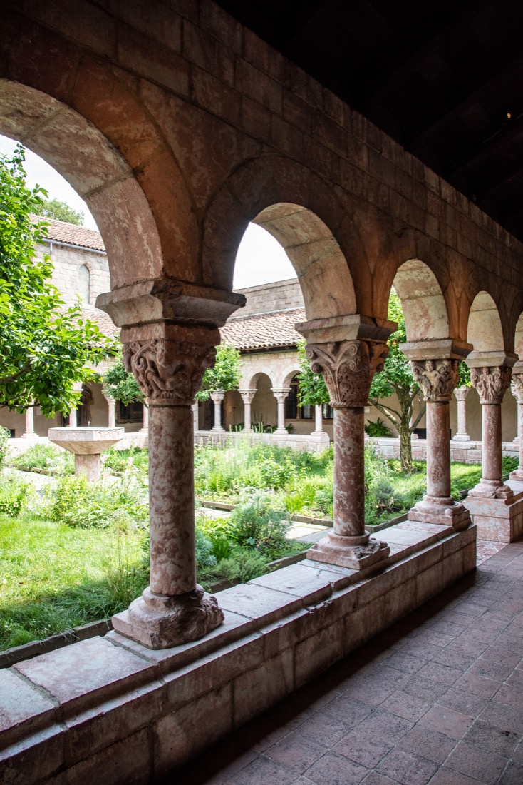 Dark cloisters with arches and columns at 
