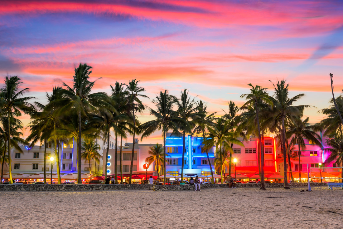 Sunset over Miami Beach Ocean Drive with buildings lit up