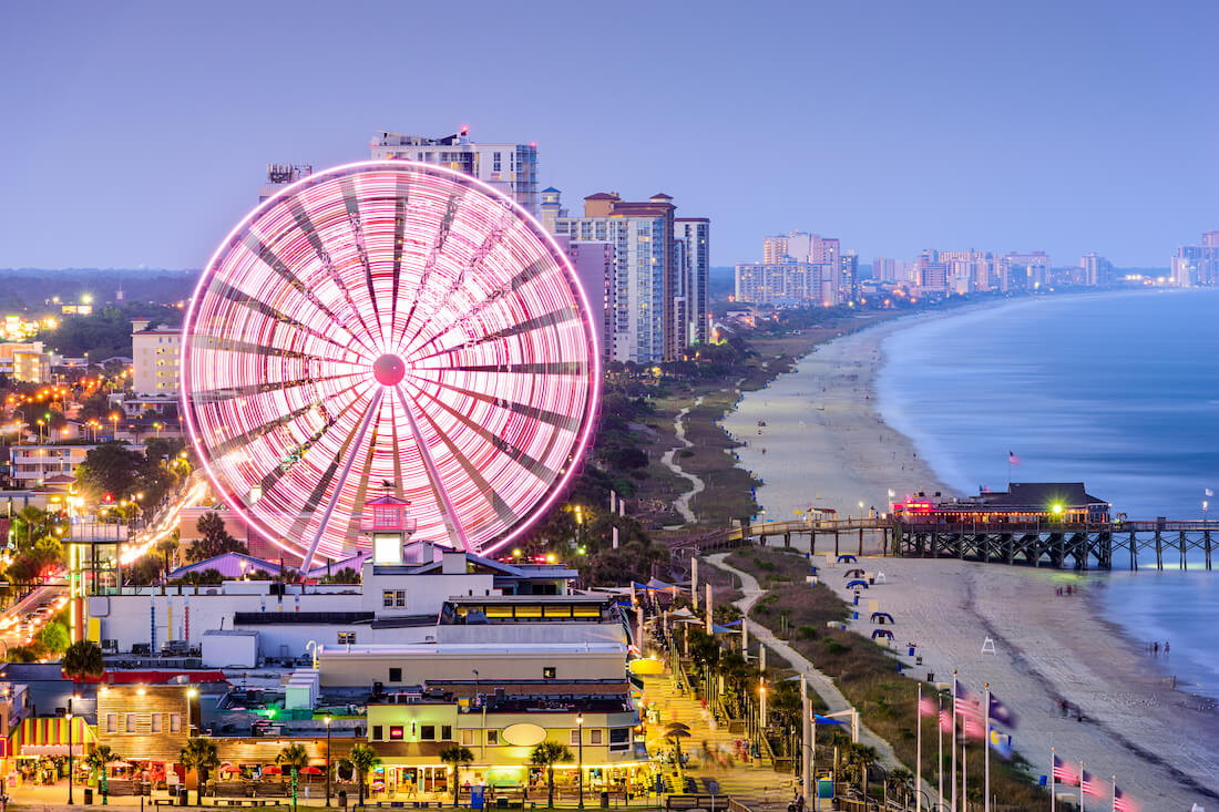 A view of the SkyWheel in Myrtle Beach spinning and lit up in the evening along the beachfront
