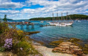 Rocky coast and view of boats in the harbor at Bar Harbor,