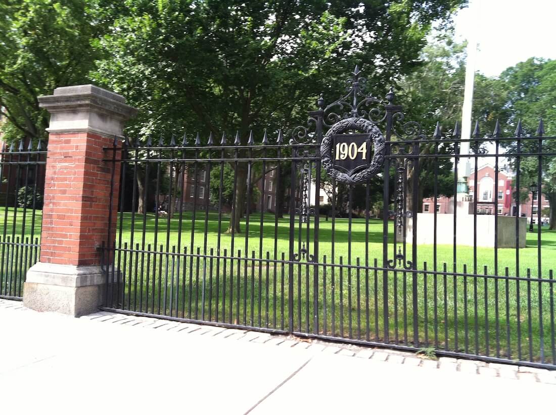 Wrought iron fence around Brown University campus with a plaque that reads 1904