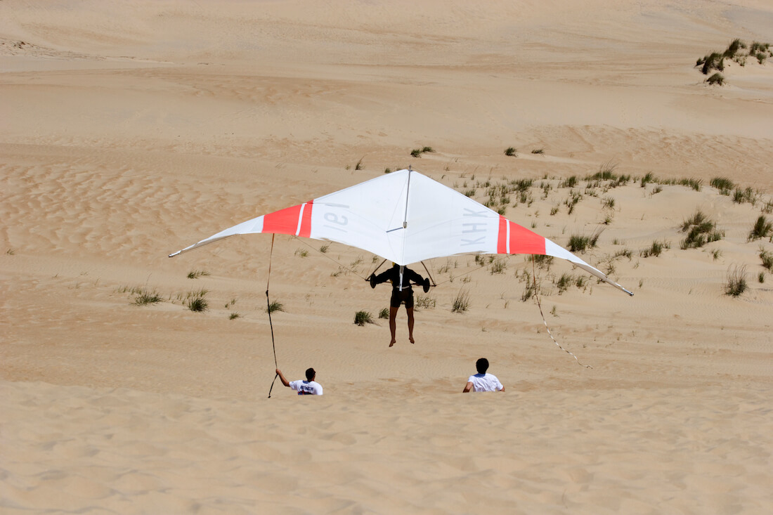 View from behind as someone takes off on a hang glider at Jockey's Ridge State Park in North Carolina
