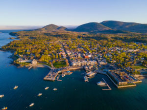 Aerial view of Downtown Bar Harbor Maine at sunset with Acadia National Park in the background