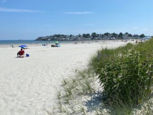 Dunes and soft white sand of Nahant Beach Massachusetts with homes on Nahant in the background