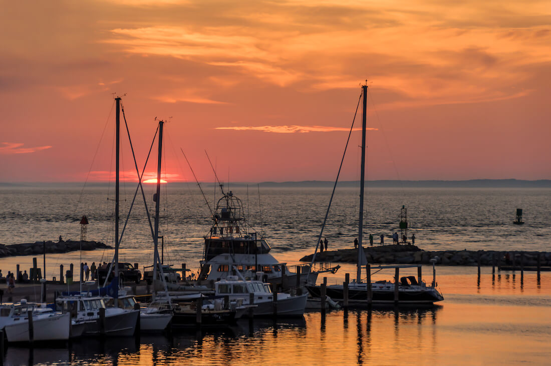 Bright orange sunset sky over a small harbor in Menemsha, Martha's Vineyard, Massachusetts