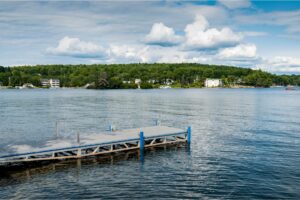 Scenic Views of Long Lake with a pier and greeneries in Naples, Maine