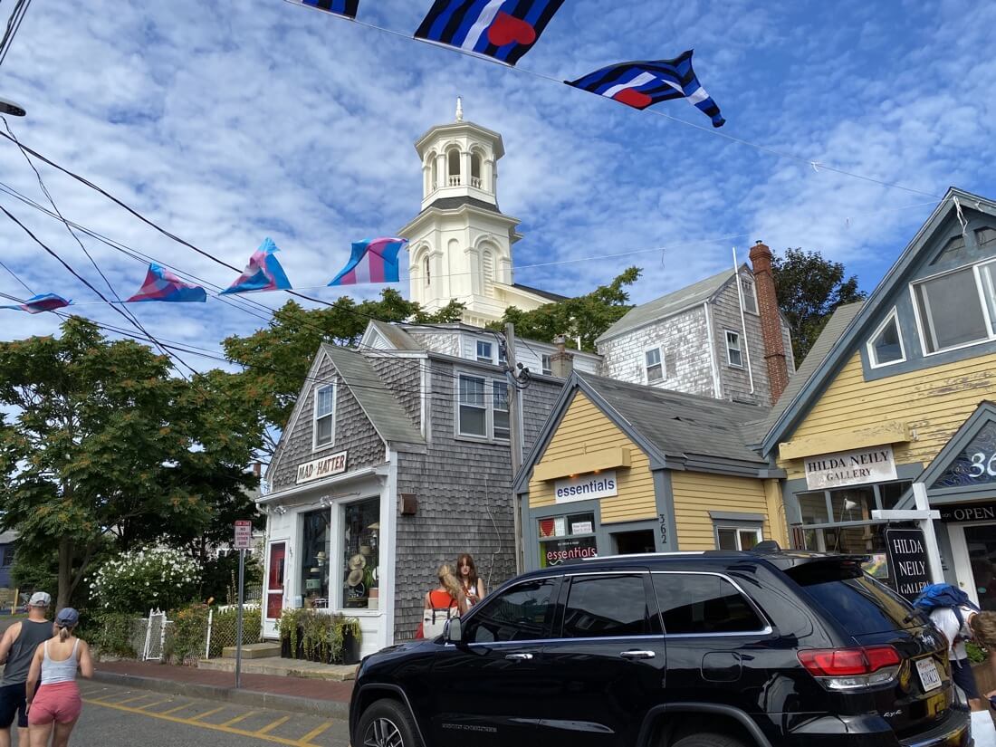 View of Commercial Street with flags waving overhead in Provincetown Massachusetts