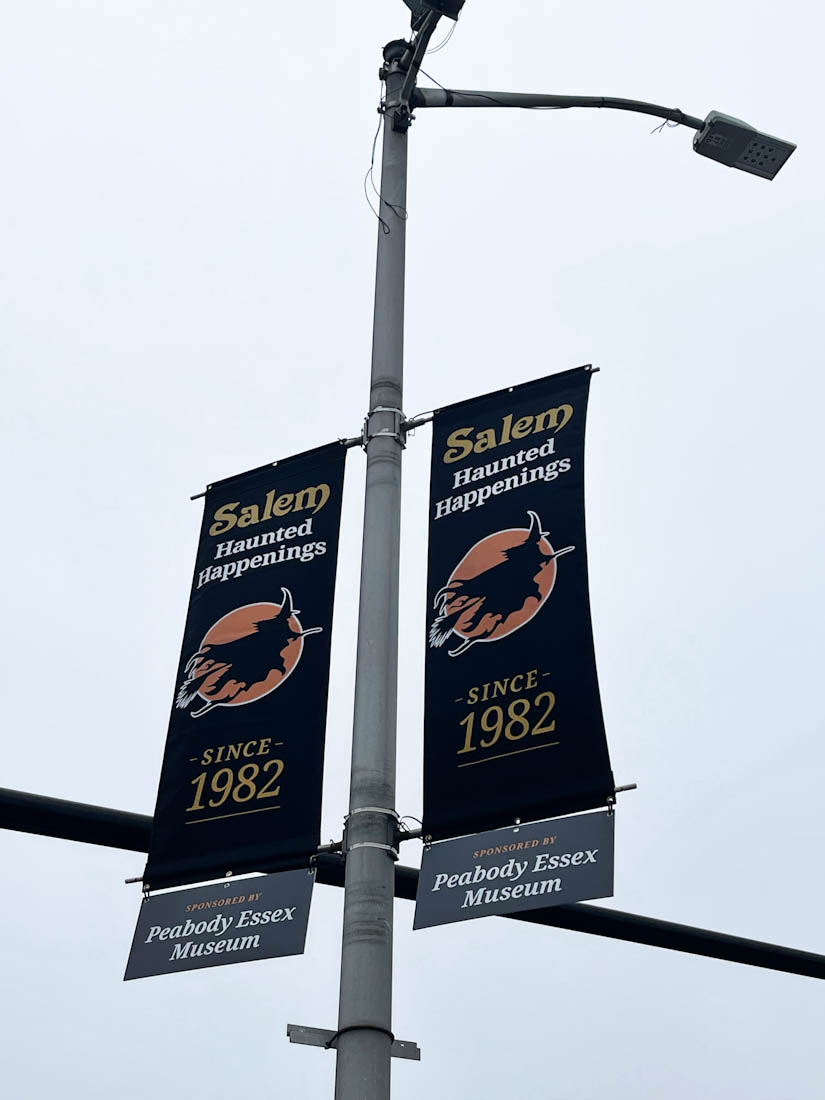 Salem Haunted Happenings banner signs hanging on a light pole in Salem Massachusetts