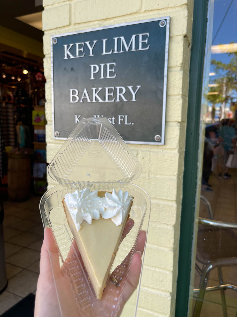 Key Lime Pie held up against Key Lime Pie Bakery sign
