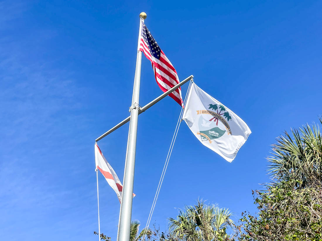 Naples flags near beach pier in Florida