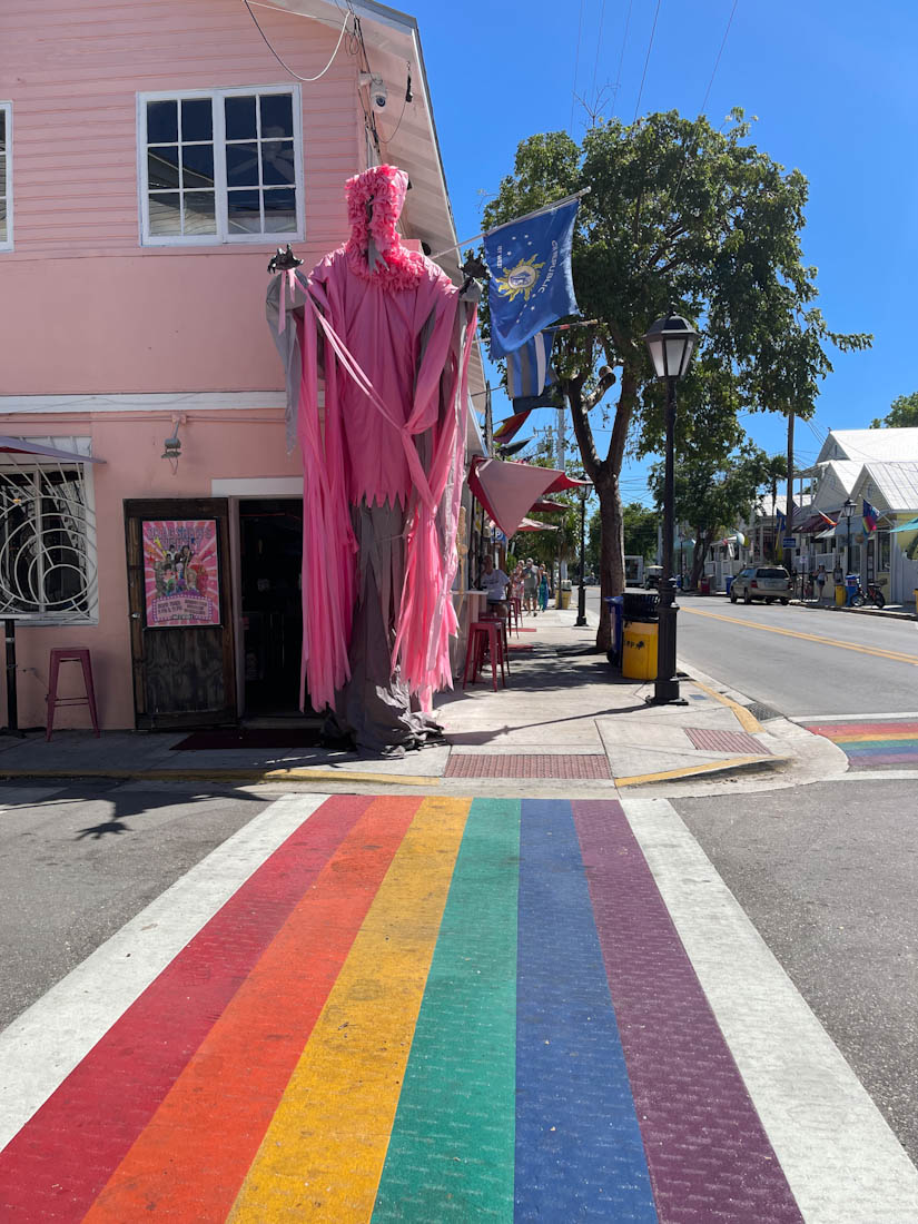 Rainbow Crosswalks and pink statue against pink house at Key West