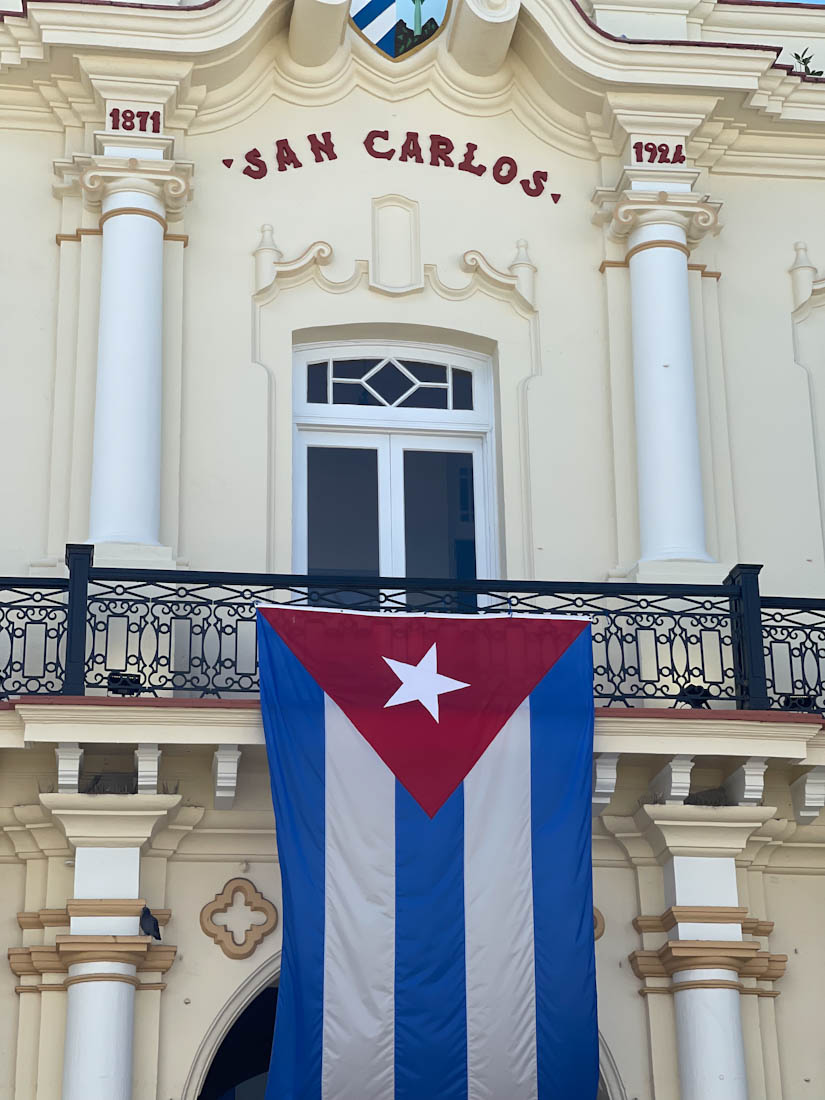 White building with San Carlos sign and Cuba flag