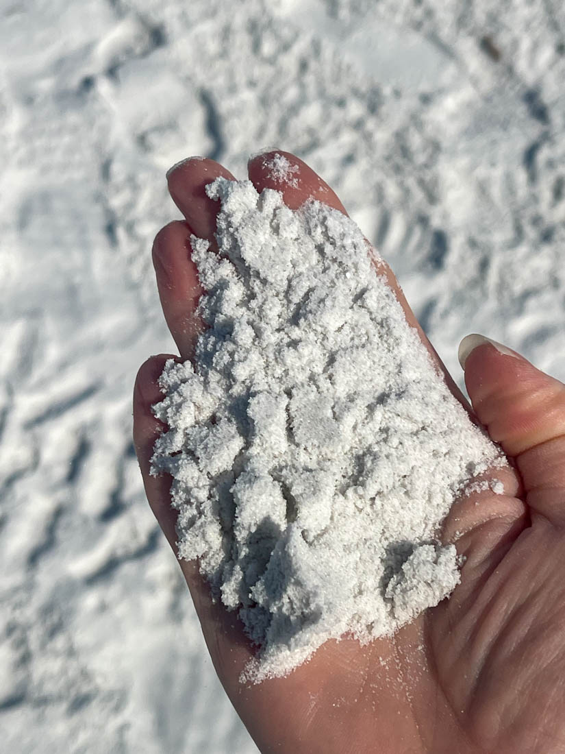 Hand holding white sugar quartz sand at Siesta Key Beach in Florida