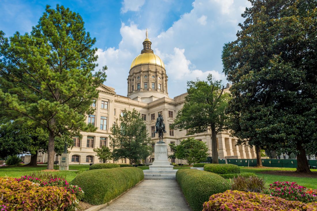 Georgia State Capitol Building in Atlanta with trees and bushes.