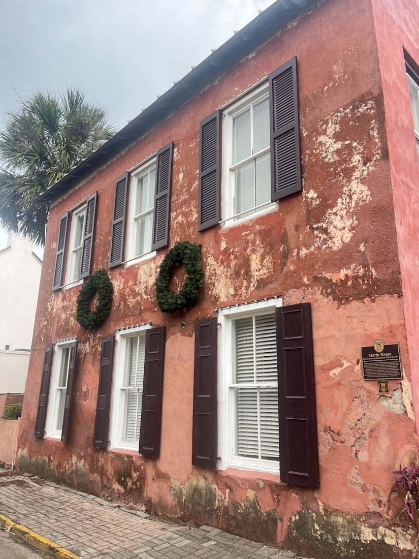 Pink colored Marin House with wreaths above windows in St Augustine Florida