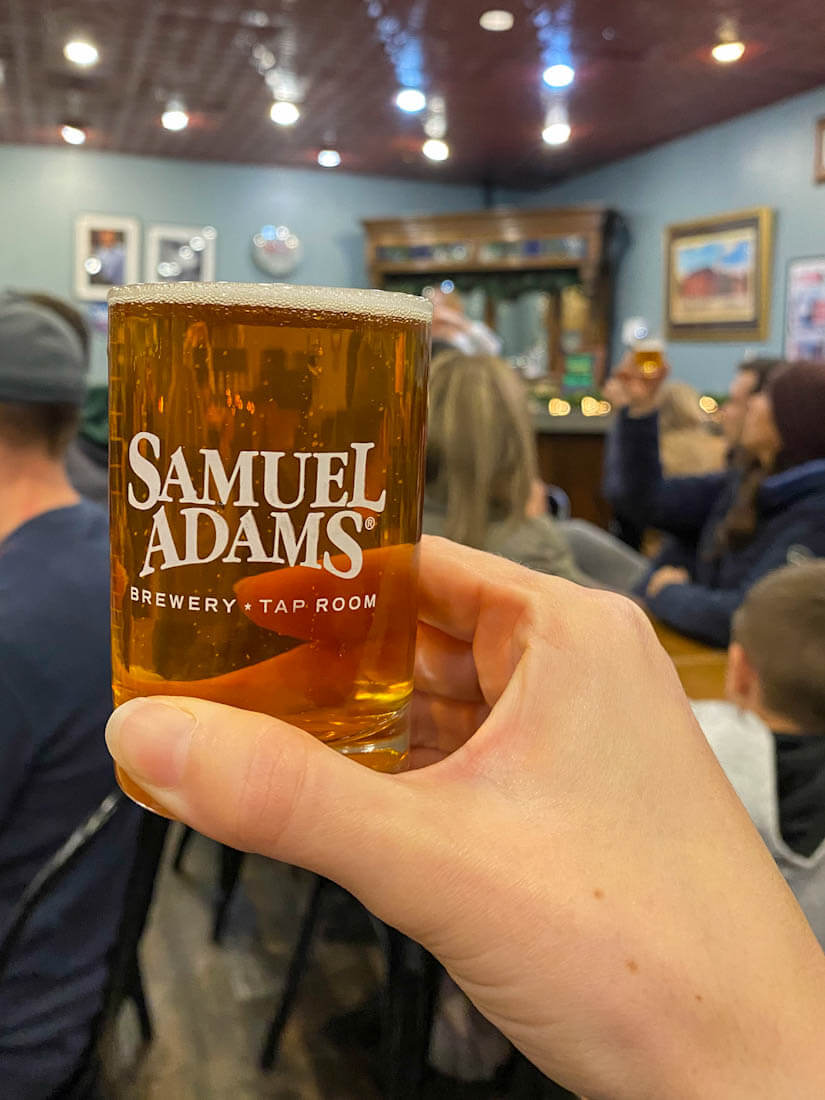 Hand holding Sam Adams beer in tap room 