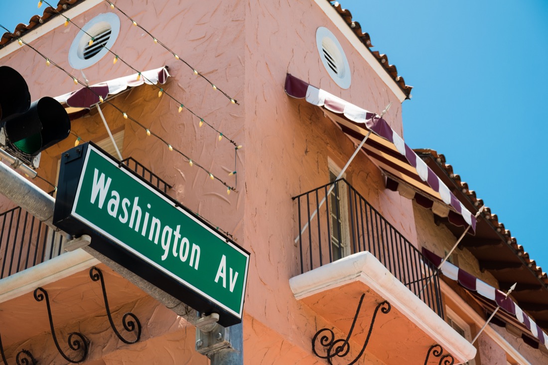 Peach colored building at Espanol Way Miami Beach with Washington Ave sign 