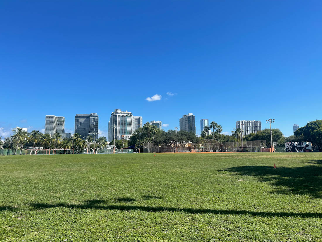 Blue skies green grass with Miami skyline at Roberto Clemente Park Miami Florida