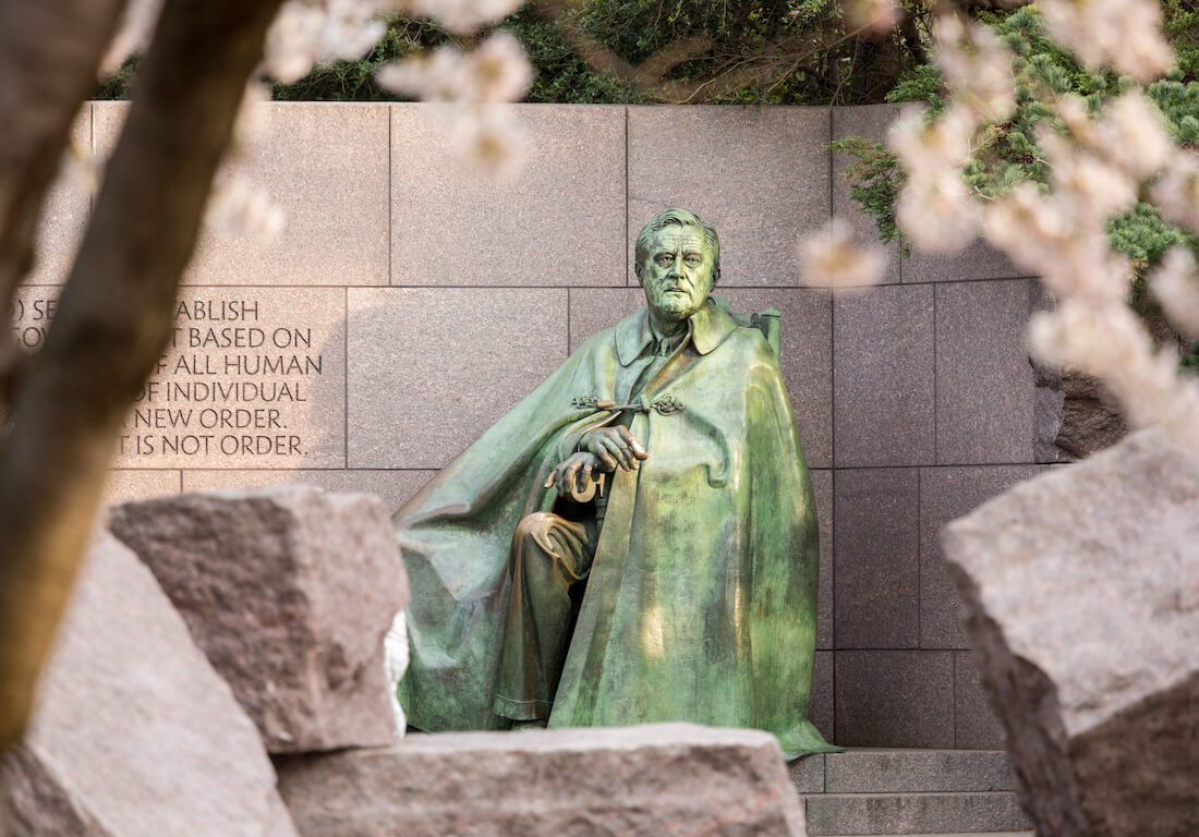 Statue at the Franklin Delano Roosevelt Memorial (FDR) in Washington DC framed by cherry blossoms