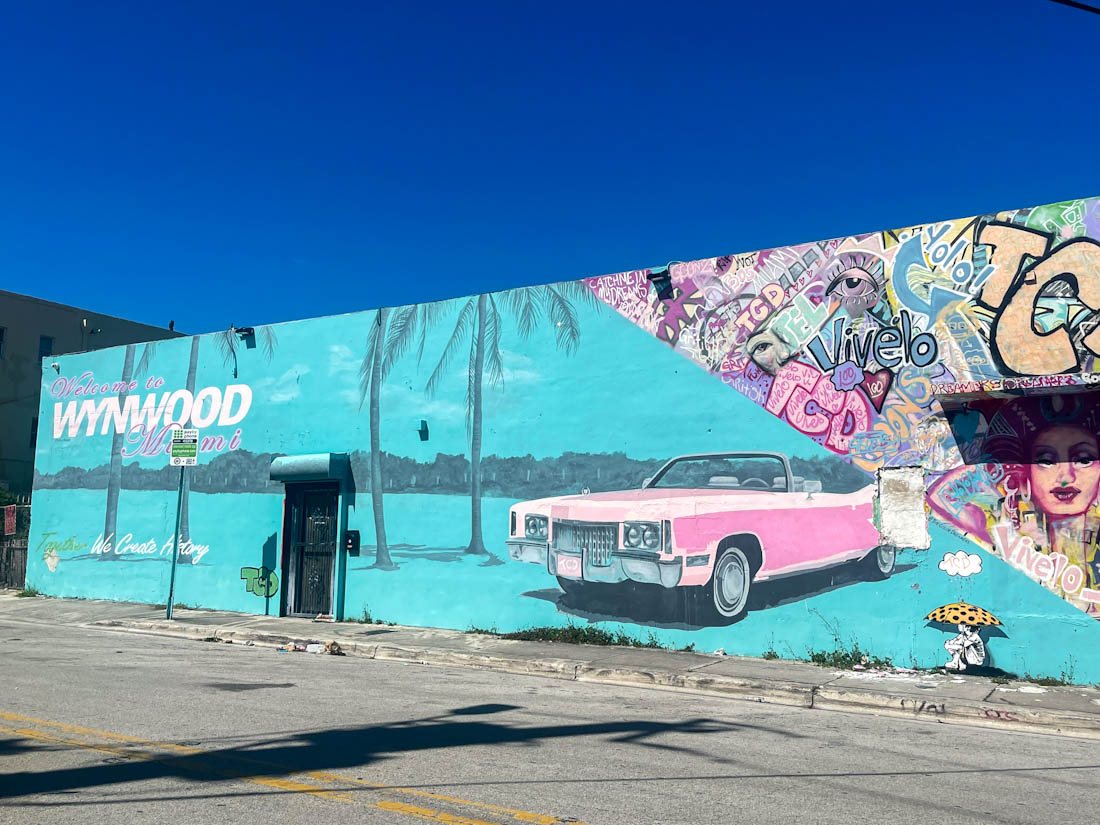 Welcome to Wynwood sign wall in teal with pink car in Miami