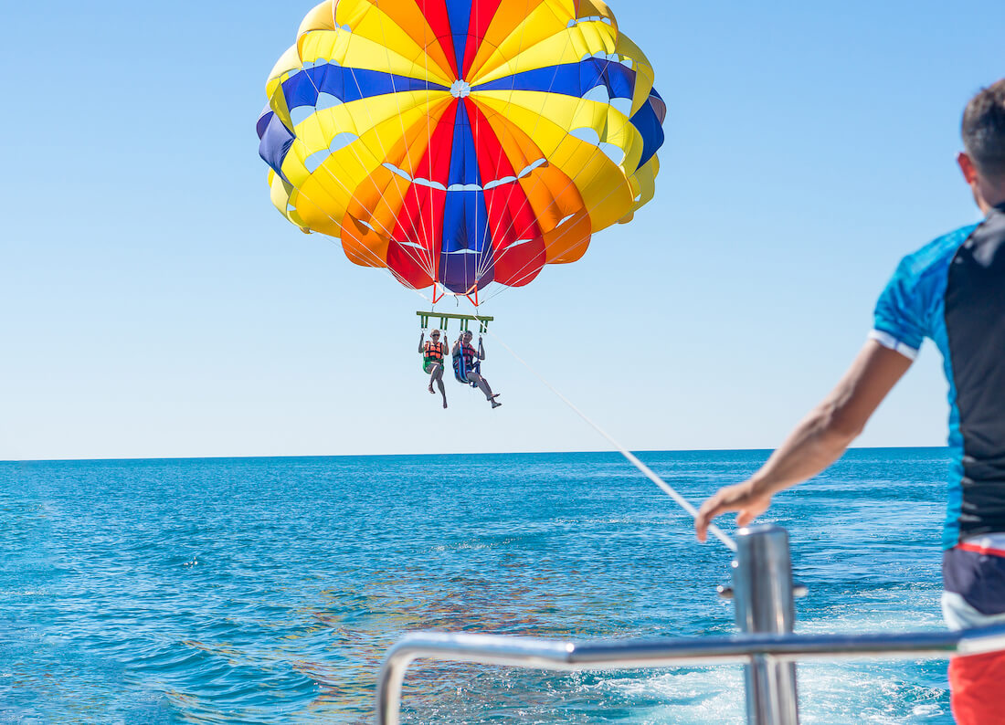 Two people parasailing over open water