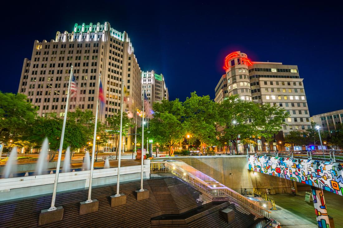 Fountains and buildings with lights at downtown Bethesda during nighttime.