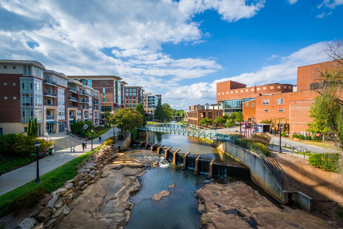 View of Reedy River surrounded by buildings in Downtown Greenville, South Carolina.