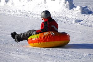 Child sledding on snow tube