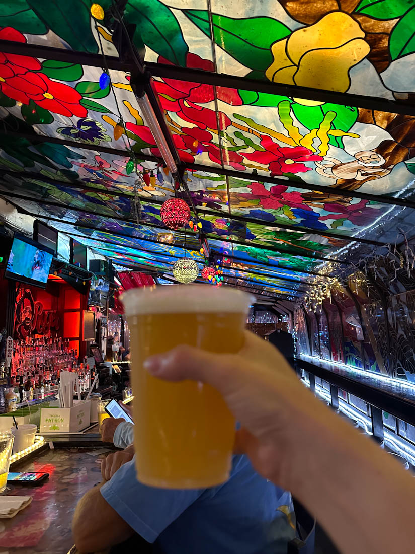 Hand holding pint of beer in colorful bar The Jolly Rodger in Kill Devil Hills