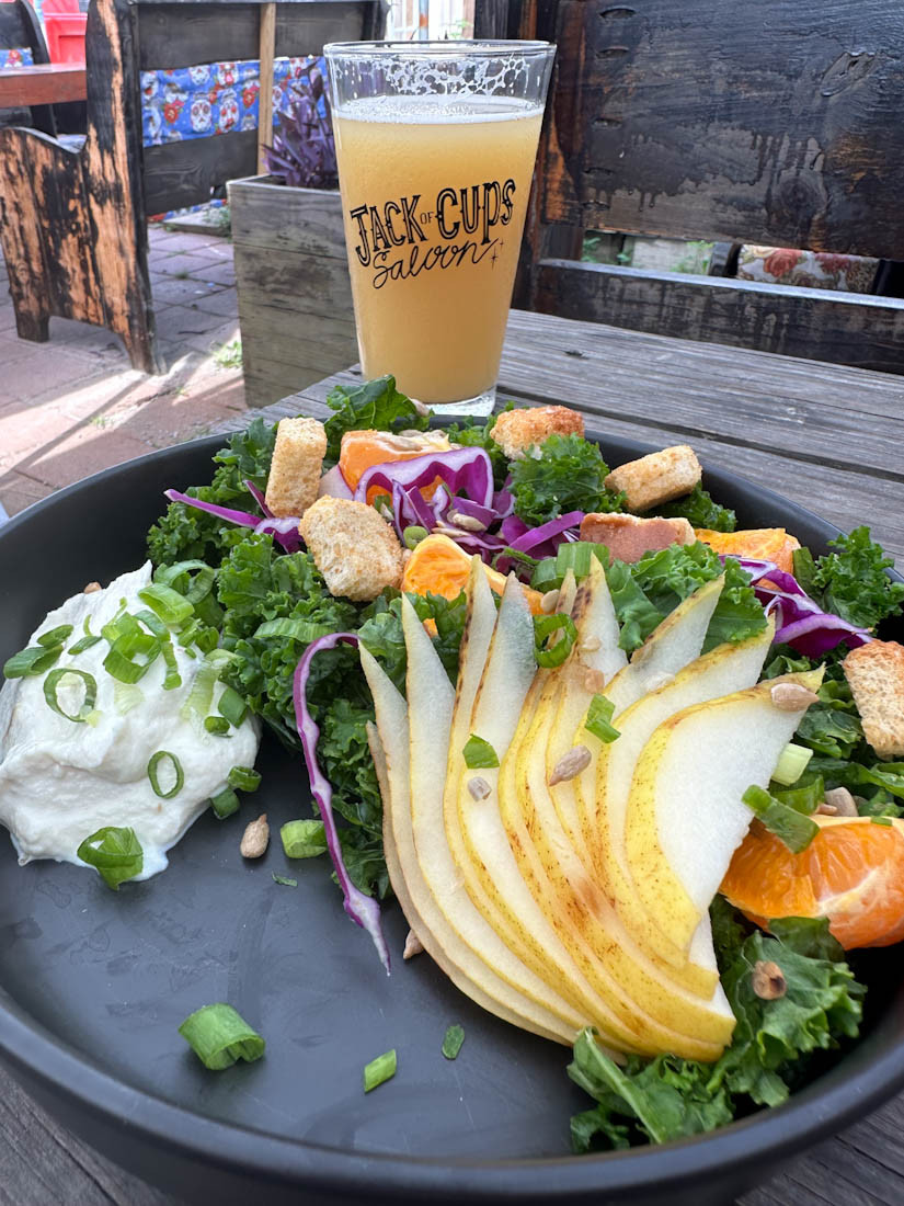 Salad on table with Jack of Cups beer glass at Folly Beach 