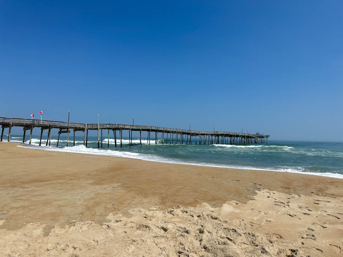 Blue waters and golden sand at Avon Beach Pier in the Outer Banks of North Carolina