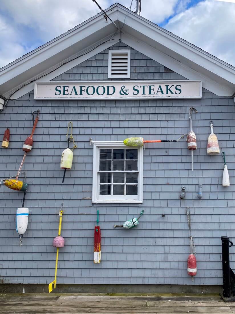 Seafood and Steaks sign and buoys in Boothbay Harbor Maine